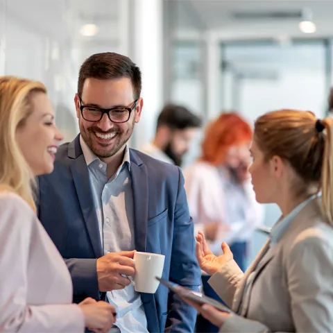 Business people chatting in office lobby. Business people standing and discussing about new project. Business, coworkers and communication concept.